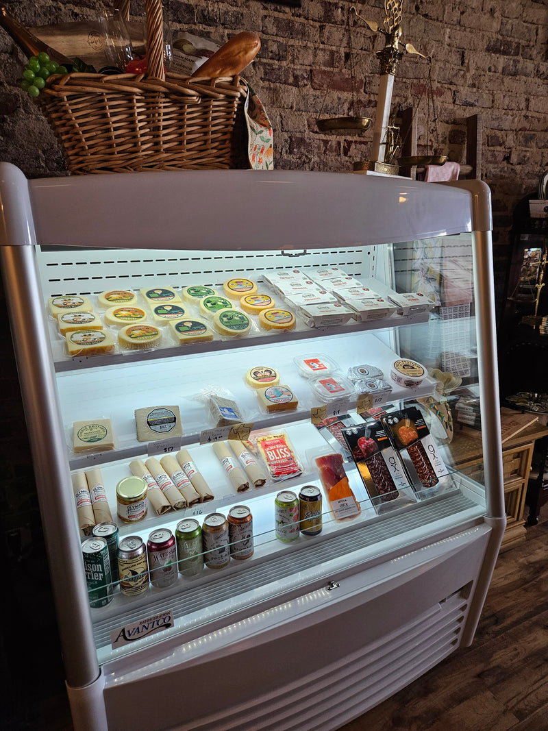 Deli counter with cheese, meats, and charcuterie in a rustic setting