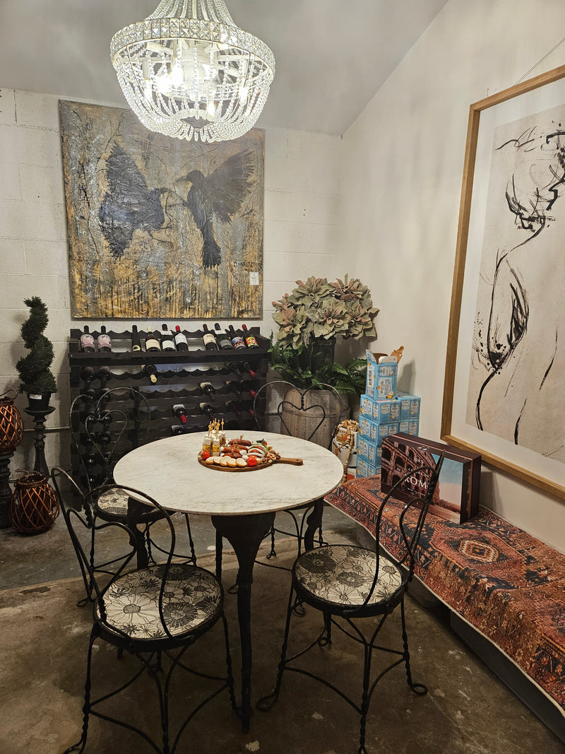 Decorative interior with a table, chairs, and wall art in a wine storage room.