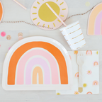 Colorful rainbow-themed plates, cups, and napkins on a light gray background