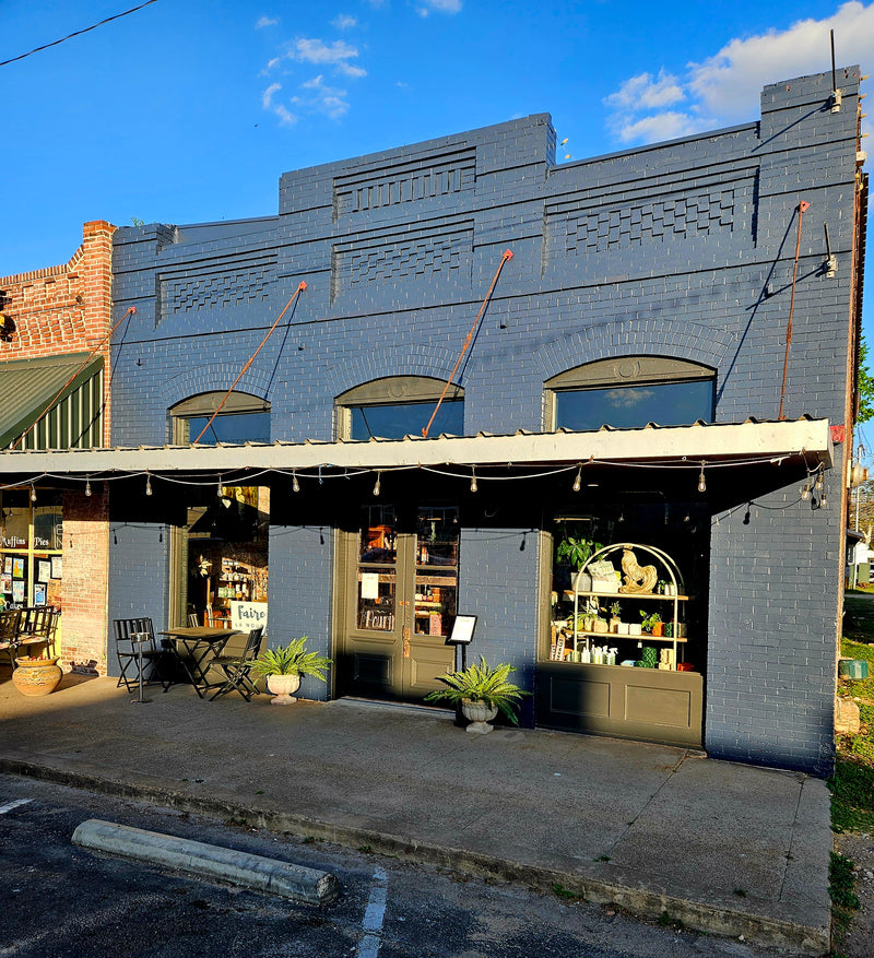 Blue brick building with storefronts on a sunny day