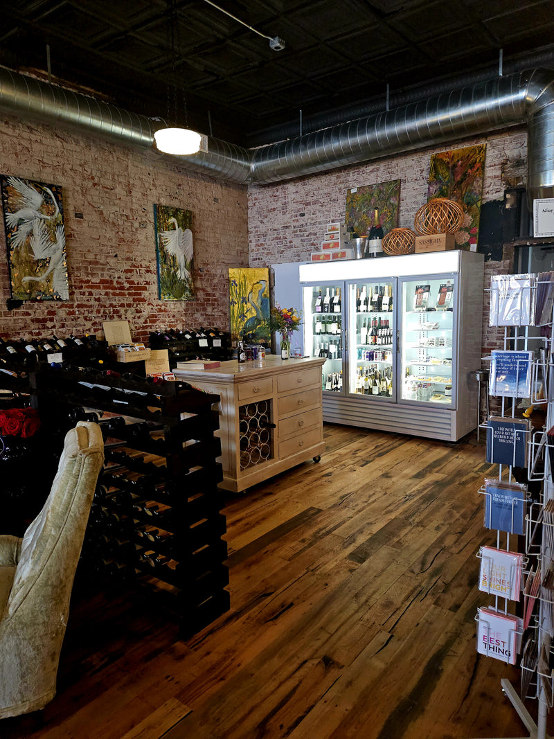 Interior of store with a refrigerator full of wine and craft beer.